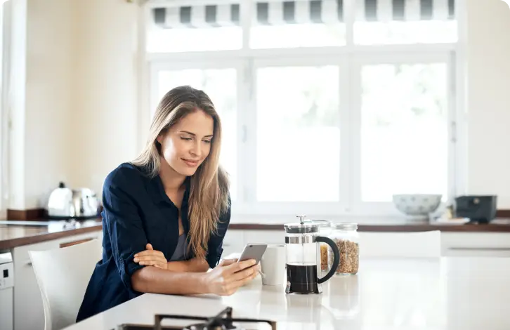 Donna che usa il telefono al tavolo